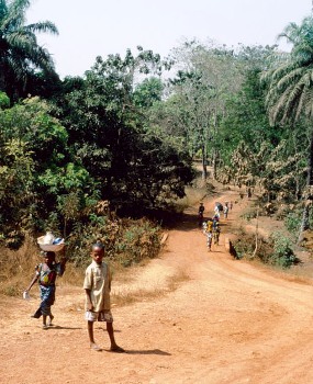 Featured is a photo of children in Guinea, Africa on their way home from school. Photographer unknown.